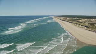 AX144_010E - 5.5K aerial stock footage flying over waves rolling onto beach, Cape Cod, Truro, Massachusetts