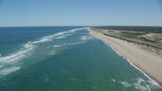 AX144_011 - 5.5K aerial stock footage flying over waves rolling onto the beach, Cape Cod, Truro, Massachusetts