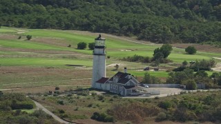 AX144_015 - 5.5K aerial stock footage flying by Highland Light, dense forest, Cape Cod, Truro, Massachusetts