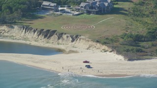 AX144_124 - 5.5K aerial stock footage of an isolated beachfront mansion, trucks on beach, Chappaquiddick Island, Martha's Vineyard, Massachusetts