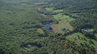 AX144_156 - 5.5K aerial stock footage over rural homes, approach ponds, West Tisbury, Martha's Vineyard, Massachusetts