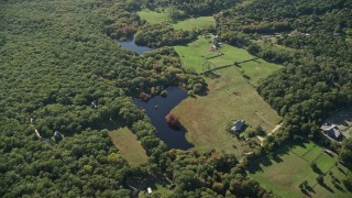 AX144_156E - 5.5K aerial stock footage over rural homes, approach ponds, West Tisbury, Martha's Vineyard, Massachusetts