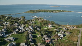 AX144_176E - 5.5K aerial stock footage of a coastal community near pond, Cuttyhunk Island, Elisabeth Islands, Massachusetts