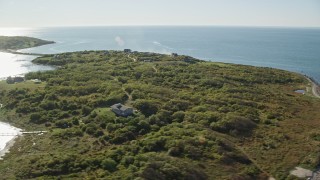 AX144_178 - 6k aerial stock footage flying by oceanfront homes, Cuttyhunk Island, Elisabeth Islands, Massachusetts