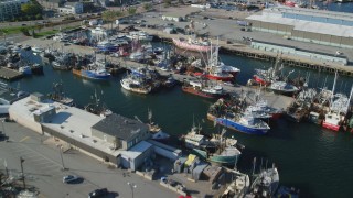 AX144_194 - 6k aerial stock footage flying over piers, fishing boats, tilt down, New Bedford, Massachusetts