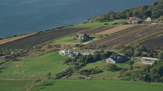 AX144_221 - 6k aerial stock footage flying by upscale home with ocean view, farms, Little Compton, Rhode Island