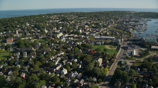 AX144_229E - 6k aerial stock footage flying by coastal community, harbor in the distance, Newport, Rhode Island