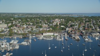 AX144_232 - 6k aerial stock footage flying by coastal community, piers, busy harbor, Newport, Rhode Island