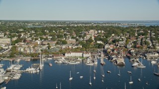 AX144_232E - 6k aerial stock footage flying by coastal community, piers, busy harbor, Newport, Rhode Island