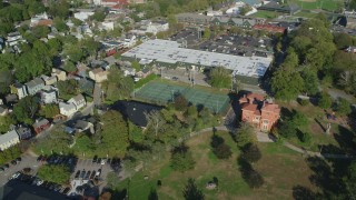 AX144_241 - 6k stock footage aerial video orbiting strip mall, tennis courts, Edward King House, Newport, Rhode Island