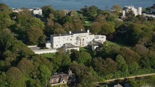 AX144_247 - 6k aerial stock footage flying by mansion surrounded by large trees, Newport, Rhode Island
