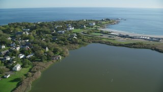 AX144_248 - 6k aerial stock footage flying by coastal community, approach oceanfront mansion, Newport, Rhode Island