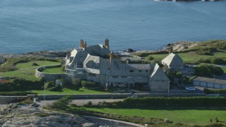 AX144_251 - 6k stock footage aerial video orbiting oceanfront mansion, coastal cliffs, Newport, Rhode Island