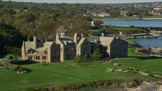 AX144_253 - 6k aerial stock footage flying by Rough Point, oceanfront mansion, rocky coast, Newport, Rhode Island