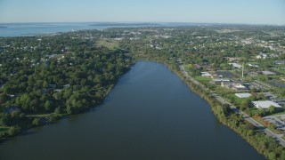 AX144_260 - 6k aerial stock footage approaching a coastal community, green trees, Newport, Rhode Island