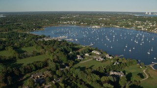 AX145_013 - 6k aerial stock footage flying by waterfront mansions, Bristol Harbor, sailboats, Bristol, Rhode Island