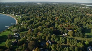 AX145_017E - 6k aerial stock footage flying over homes near the shore, colorful trees, Barrington, Rhode Island