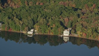 AX145_106 - 6k aerial stock footage flying by waterfront homes, Lake Mirimichi, autumn, Plainville, Massachusetts