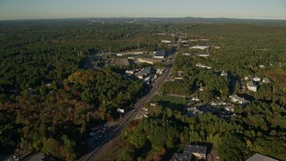 AX145_120E - 6k aerial stock footage flying over Boston Providence Highway, warehouses, autumn, Walpole, Massachusetts