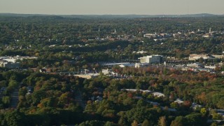 AX145_127 - 6k aerial stock footage flying by office buildings, colorful trees, autumn, Norwood, Massachusetts