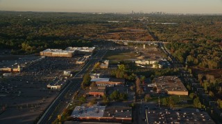 AX146_001E - 6k aerial stock footage flying by office buildings, warehouses, autumn, Westwood, Massachusetts, sunset