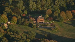 AX146_005 - 6k aerial stock footage flying by isolated mansion, autumn, Westwood, Massachusetts, sunset