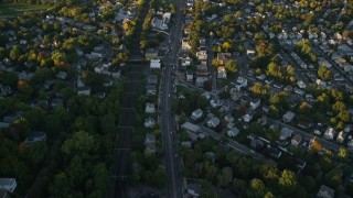 AX146_009 - 6k aerial stock footage of a bird's eye view, suburban neighborhood, autumn, Roslindale, Massachusetts, sunset