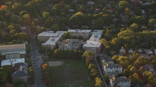 AX146_013 - 6k aerial stock footage flying by Brookline High School, Brookline, Massachusetts, sunset