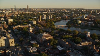 AX146_021 - 6k stock footage aerial video orbiting Harvard University, reveal Charles River, Cambridge, Massachusetts, sunset