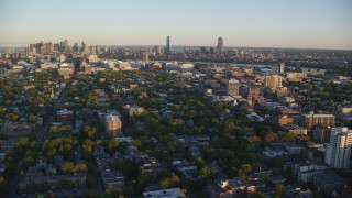 AX146_046 - 6k stock footage aerial video flying by neighborhoods, Downtown Boston skyline, Cambridge, Massachusetts, sunset