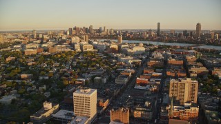 AX146_046E - 6k aerial stock footage flying by neighborhoods, Downtown Boston skyline, Cambridge, Massachusetts, sunset