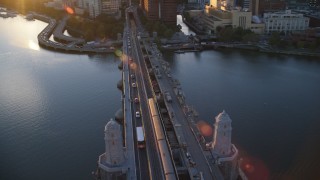 AX146_069 - 6k stock footage aerial video tracking commuter train across the Longfellow Bridge, Boston, Massachusetts, sunset 