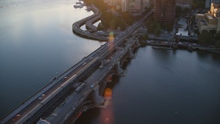 AX146_070 - 6k stock footage aerial video tracking a commuter train across the Longfellow Bridge, Boston, Massachusetts, sunset