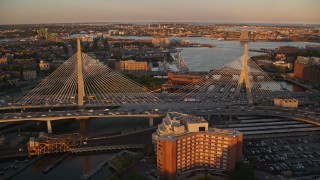 AX146_071E - 6k aerial stock footage flying over Zakim Bridge, reveal Constitution Marina, Boston, Massachusetts, sunset