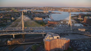 AX146_072 - 6k aerial stock footage flying over Zakim Bridge, reveal Constitution Marina, Boston, Massachusetts, sunset