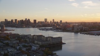 AX146_075 - 6k aerial stock footage flying by Charles River and skyline, Downtown Boston, Massachusetts, sunset