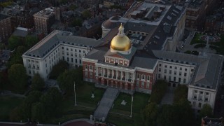 AX146_086 - 6k aerial stock footage approaching Massachusetts State House, Downtown Boston, Massachusetts, sunset