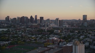 AX146_093E - 6k aerial stock footage flying by Bunker Hill Monument, downtown skyline, Charlestown, Massachusetts, sunset