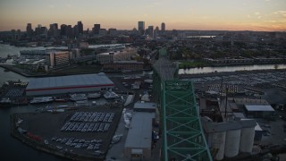 AX146_099E - 6k aerial stock footage flying by Tobin Memorial Bridge, reveal downtown skyline, Charlestown, Massachusetts, sunset