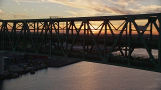 AX146_105E - 6k aerial stock footage flying by the Tobin Memorial Bridge, Charlestown, Massachusetts, sunset