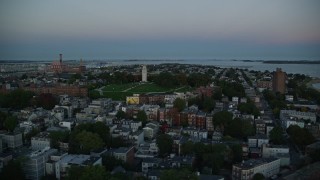 AX146_115E - 6k aerial stock footage of Dorchester Heights Monument, row houses, South Boston, Massachusetts, twilight