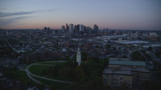 AX146_121 - 6k aerial stock footage of Dorchester Heights Monument, skyline, South Boston, Massachusetts, twilight