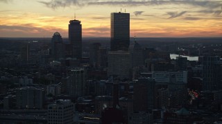 AX146_137 - 6k aerial stock footage flying by downtown buildings, skyscrapers, Downtown Boston, Massachusetts, twilight