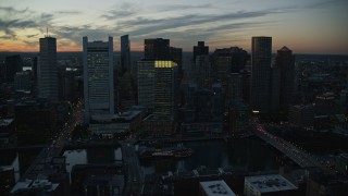 AX146_138E - 6k aerial stock footage flying over skyscrapers, tilting down, Downtown Boston, Massachusetts, twilight