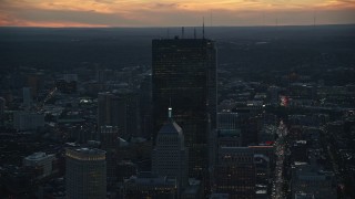 AX146_142E - 6k aerial stock footage flying by skyscrapers, Downtown Boston, Massachusetts, twilight