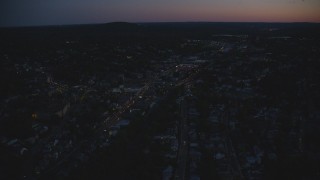 AX146_158 - 6k aerial stock footage flying over suburbs, approaching strip mall, Hyde Park, Massachusetts, night