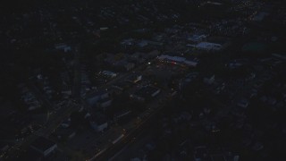 AX146_159 - 6k aerial stock footage flying by a strip mall, Hyde Park, Massachusetts, night