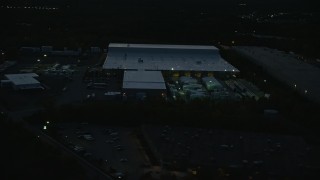 AX146_166 - 6k stock footage aerial video flying by a warehouse, Westwood, Massachusetts, night