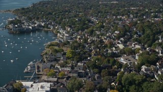 AX147_026E - 6K aerial stock footage flying over a coastal community with trees along the harbor, Marblehead, Massachusetts