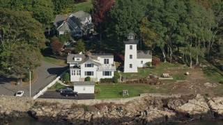 AX147_053 - 6K aerial stock footage of a lighthouse nestled among trees along cove, autumn, Beverly, Massachusetts